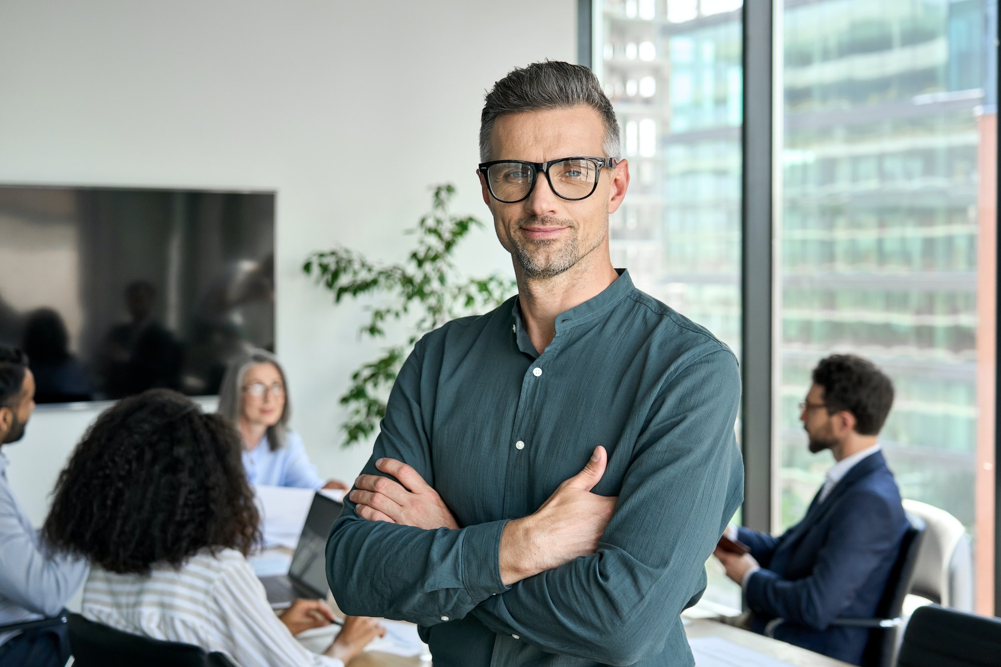 Smiling confident mature businessman leader looking at camera in office.